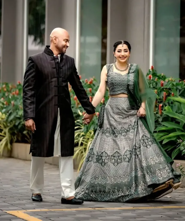 Bride and groom walking hand in hand in their wedding reception attire