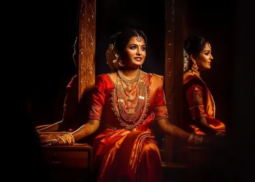 Bride in traditional red wedding attire standing beside a mirror